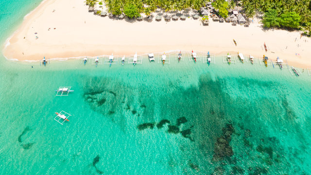 Beautiful tropical island in sunny weather, view from above. Daco island, Philippines. White sandy beach and turquoise lagoon.