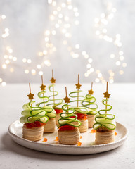 Christmas tree canape with cucumber slice, salmon pate and red caviar
