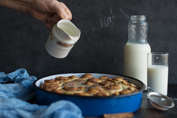  Baker putting sugar glaze syrup on to baked cinnamon buns