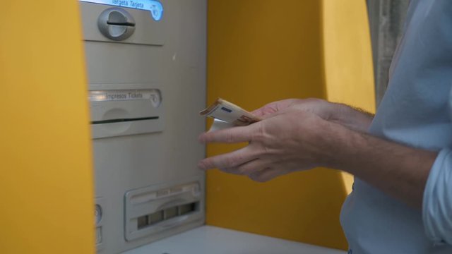 Close up of man's hand insert ATM card into Automated teller machine (Automatic banking machine) to withdraw cash money, Banking and Business Concept.