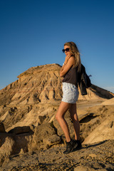 Naklejka premium Lifestyle of a young blonde with rocker outfit with the jacket on her back in the desert