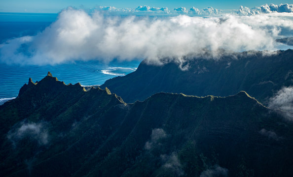 Clouds rimming ridge tops of Na'Pali coast with ocean in background