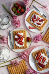 Fototapeta na wymiar Waffles with strawberries and whipped cream