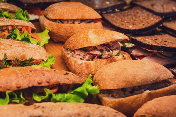 Beautifully decorated catering banquet table with different food snacks and appetizers with sandwich, on corporate christmas birthday kids party event or wedding celebration