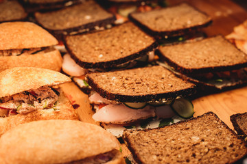 Beautifully decorated catering banquet table with different food snacks and appetizers with sandwich, on corporate christmas birthday kids party event or wedding celebration