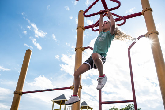 Below View Of Girl Swinging On Monkey Bars