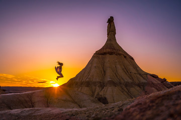 Lifestyle session of a girl with a dress jumping at sunset in Las Bardenas, Navarra. Spain