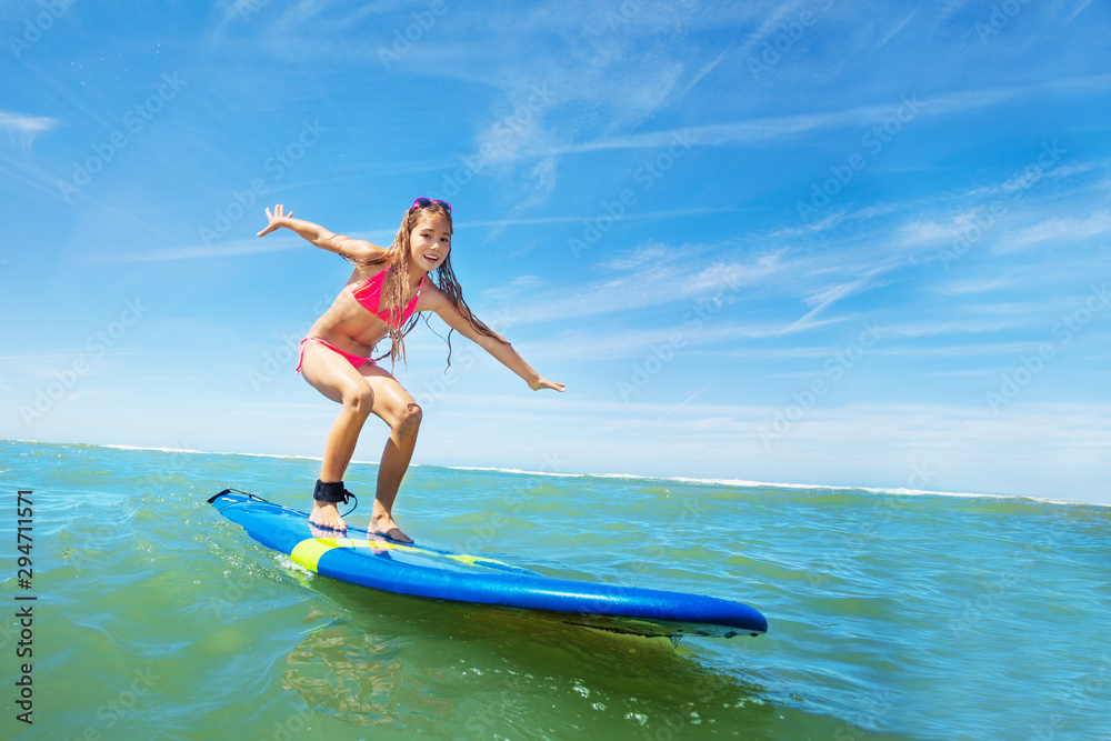 Wall mural happy beautiful girl learn to surf on surfboard