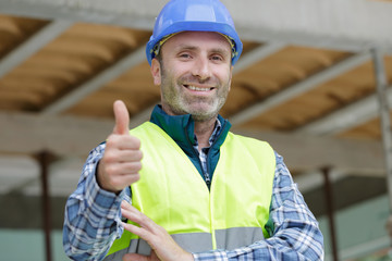 handsome construction worker showing thumb up