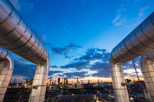Sunset as viewed through pipe in refinery