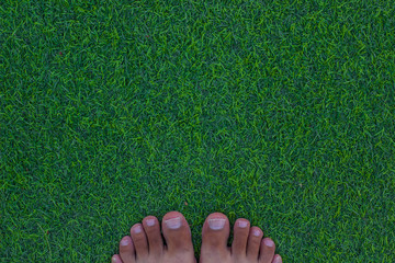 boy feet toes on outdoor green synthetic grass top view wallpaper background picture with empty copy space for your text