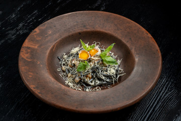 A plate of delicious pasta with bacon, cheese and quail egg.