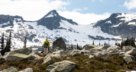 Low angle view of women hiking in mountains backed by snow and rock
