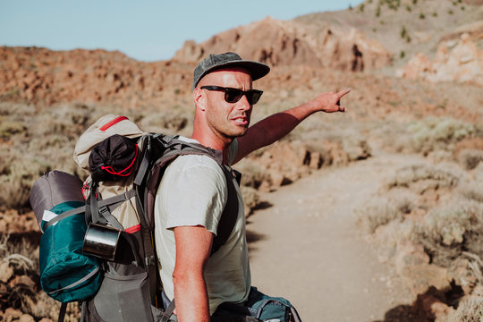 A hiker points out the way to go on the mountain, el Teide, Tenerife