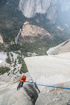 A climber ascends a rope high up on el Capitan