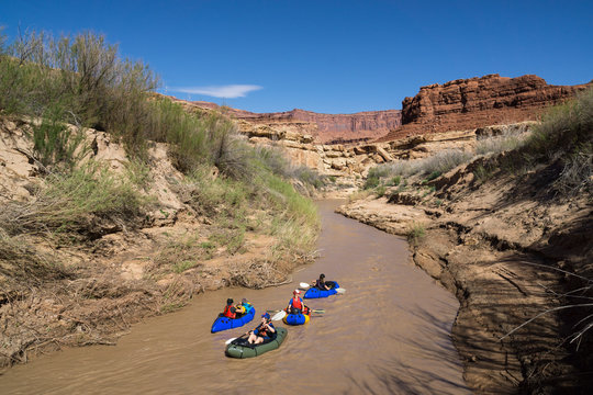 A group of women packrafting on a desert river