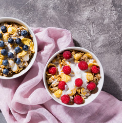 Breakfast. Granola with blueberries and raspberries on a gray background top view