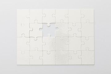 top view of completed jigsaw puzzle without one piece on white background