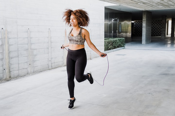 Woman skipping rope in urban area