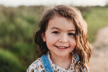 Portrait of young school-aged girl with brown eyes smiling at camera