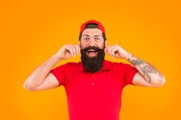 Tips for growing and maintaining moustache. Cool and stylish. Man bearded hipster twisting mustache orange background. Barber salon. Moustache grooming guide. Hipster handsome guy touching moustache