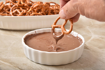 Dunking a pretzel into chocolate