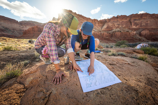 Two women looking at a map in the desert