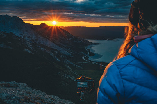 Photographer watching sunrise from mountain ridge
