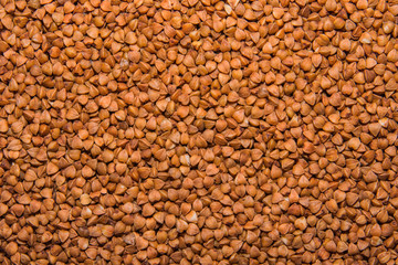 Background texture of whole grains of buckwheat. Image food product porridge buckwheat grains. Soft selective focus.