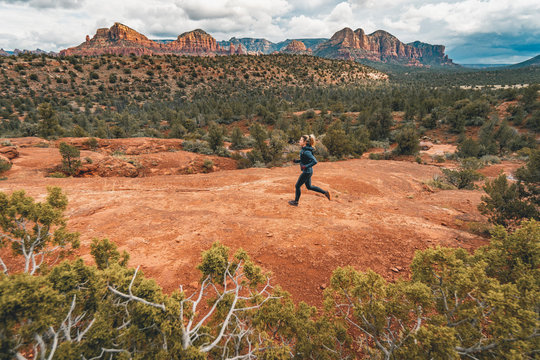 Woman trail running in epic Sedona landscape, Arizona