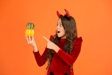 Small imp girl play with pumpkins. Decorations for holidays. Grocery shop. Happy holidays. Cute...