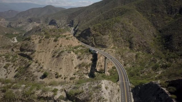 AERIAL: Car driving over bridge through Tehuacan Landscape along Highway 135D from Puebla to Oaxaca in Mexico.