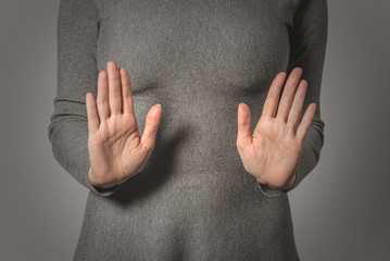 Woman showing a refuse hand gesture sign.