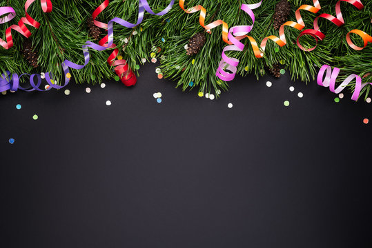 Christmas border with pine decorated branches on a black background