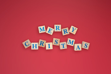 New year or Christmas holidays composition on red background with text merry christmas in center of wooden cubes.