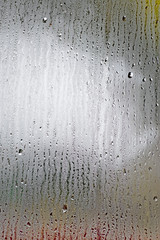 Drops of night rain on window, on back plan  light washed away
