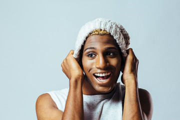 Portrait of a young man with knit cap in studio having fun