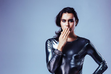 Portrait of a young man with long hair and silver top in studio