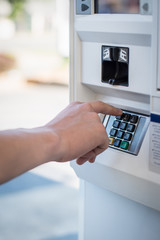 Hand entering credit card PIN code at the gas pump