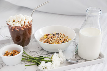 Tray with tasty breakfast on bed