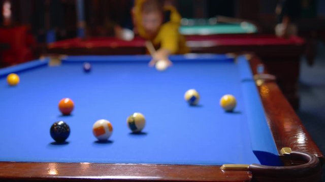 young male professional pool player playing snooker.