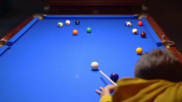 young male professional pool player playing snooker.