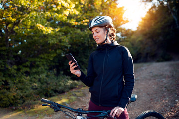 Portrait of female cyclist using phone