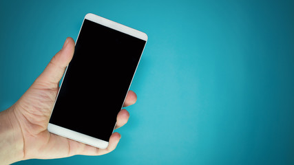 person holding phone in hand and blue background for concept photo