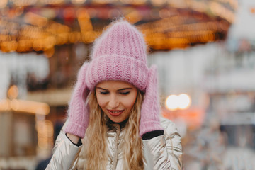 Outdoor portrait of girl wearing knitted hat and mittens.