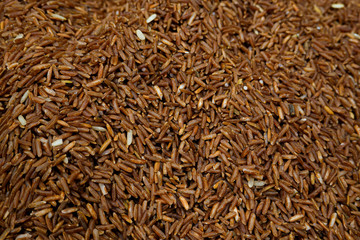 Red brown rice glutinous dry seed agriculture healthy nutrition for cooking diet food with more fiber grain and protein ingredient from Asian Thai food textured background