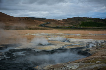 Boiling mudpots in the geothermal area Hverir and cracked ground around, Iceland in summer. Myvatn region, North part of Iceland