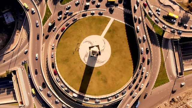 Aerial flying rise over road junction with moving cars and busy urban traffic speeding on the road. Junction network of transportation in Tbilisi, Georgia. Taken by drone, backspin