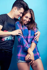 happy couple together posing cheerful on blue background , guy and girl students together friends