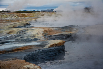 Boiling mudpots in the geothermal area Hverir and cracked ground around, Iceland in summer. Myvatn region, North part of Iceland